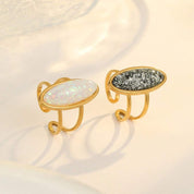 Pair of gold-rimmed earrings with gemstones on a light background