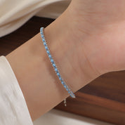 Silver and light blue cord bracelet worn on the wrist