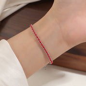 Silver and red cord bracelet worn on the wrist