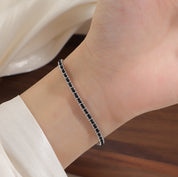 Silver and black cord bracelet worn on the wrist