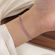 Silver and pink cord bracelet worn on the wrist