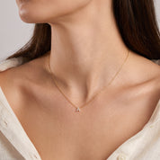 Gold crystal initial necklace with a tiny pavé letter A at the collarbone