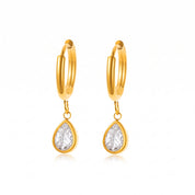 Pair of gold teardrop huggie earrings on white