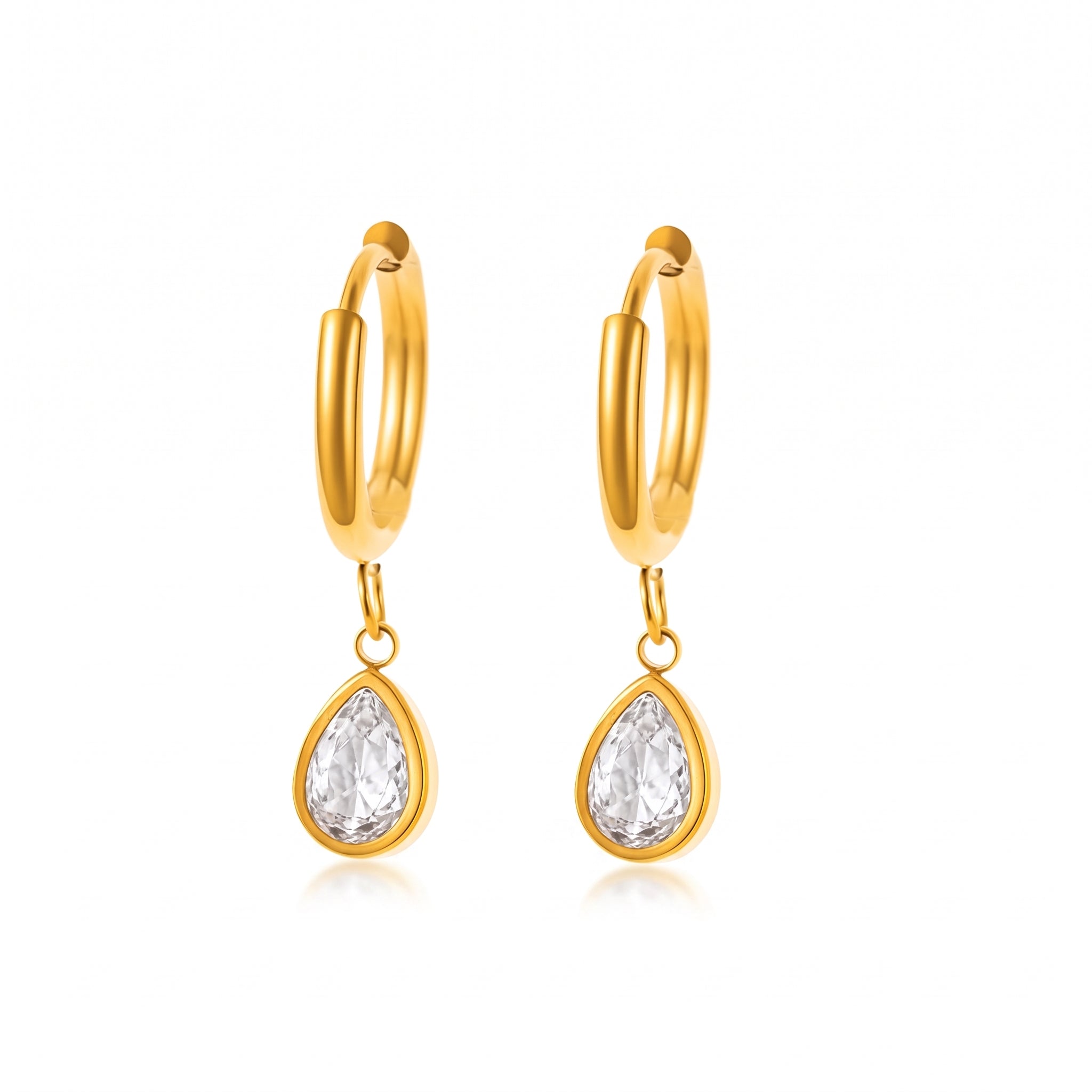 Pair of gold teardrop huggie earrings on white