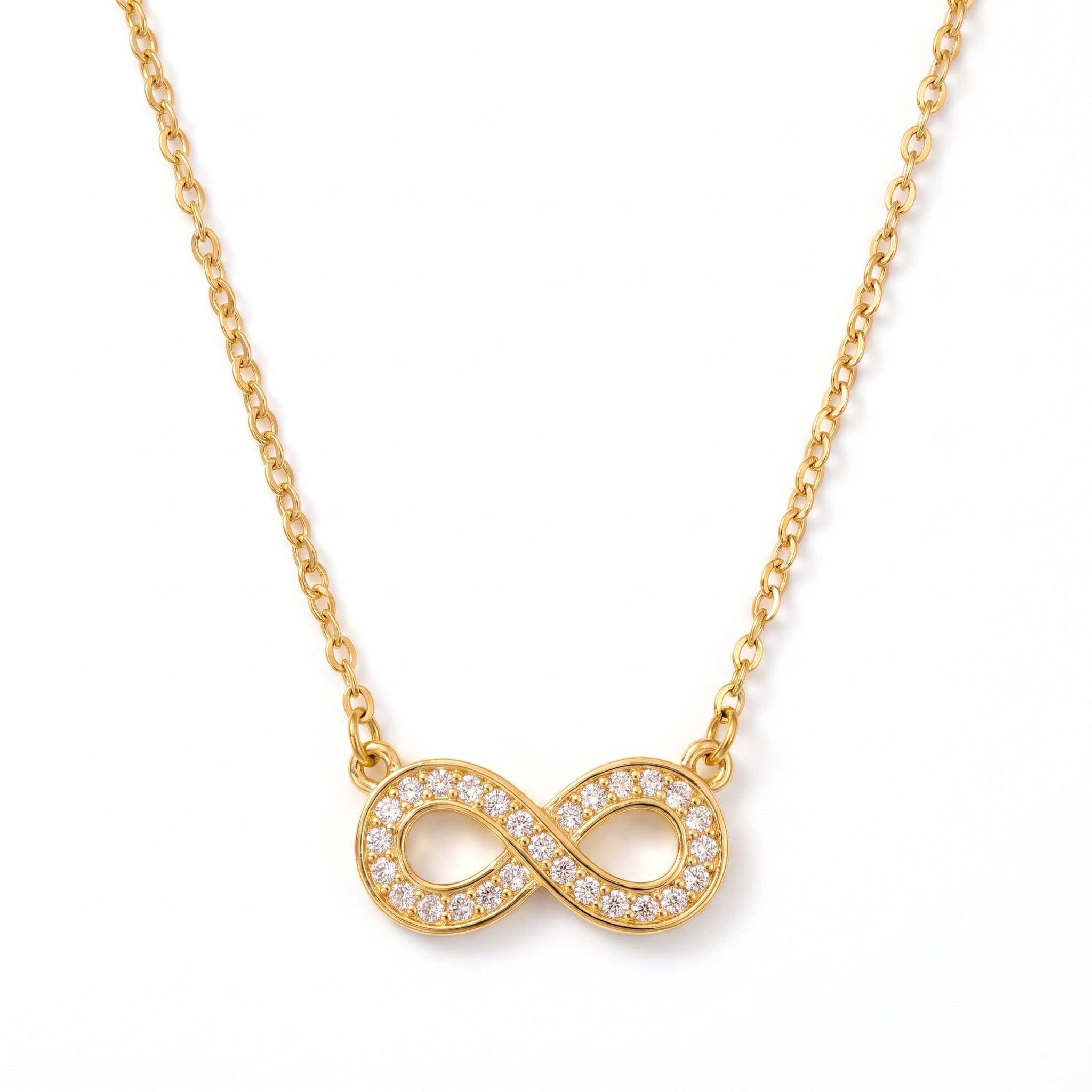 Gold pavé infinity necklace laid out on a white background