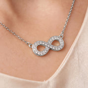 Silver pavé infinity necklace, close-up of the crystal infinity on skin