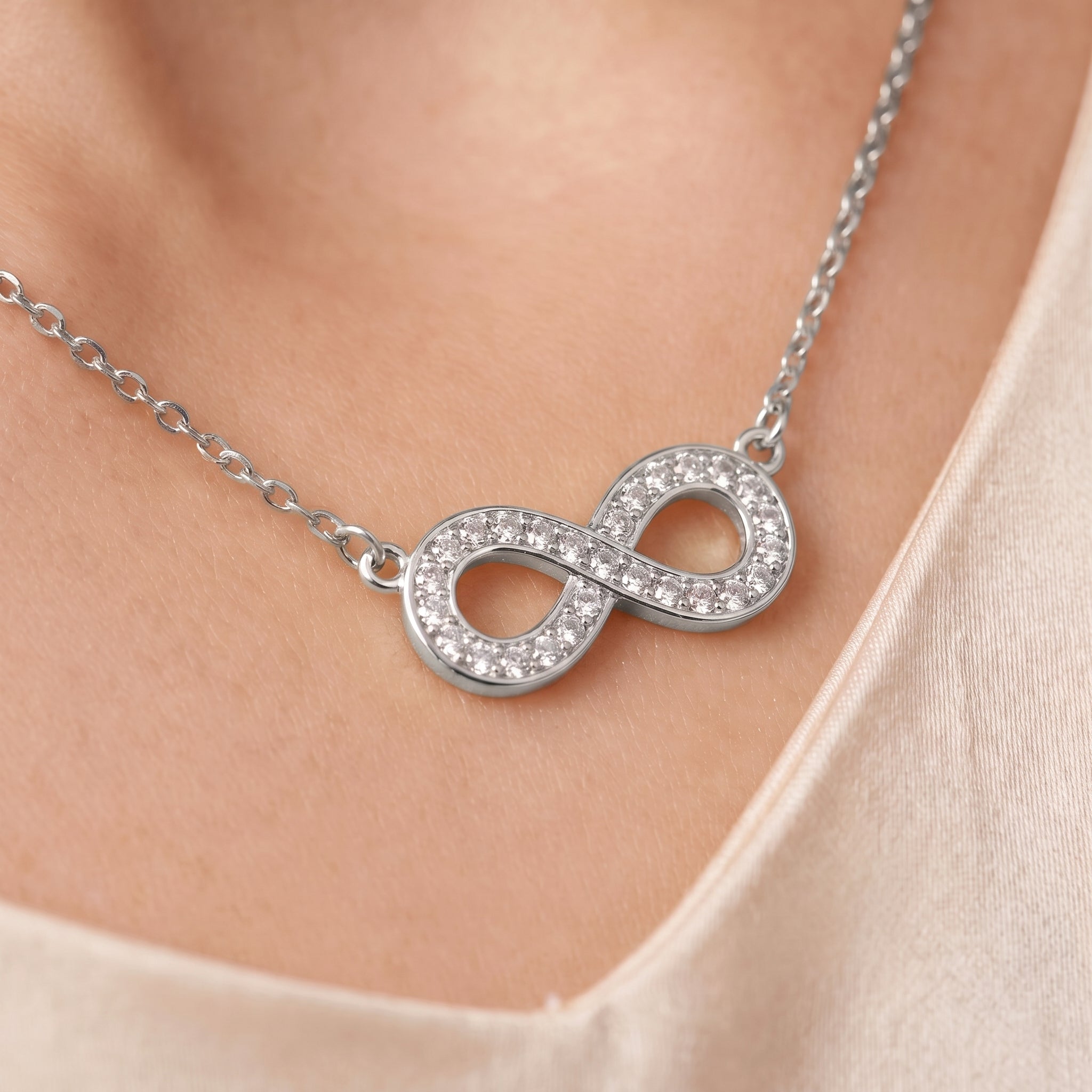 Silver pavé infinity necklace, close-up of the crystal infinity on skin
