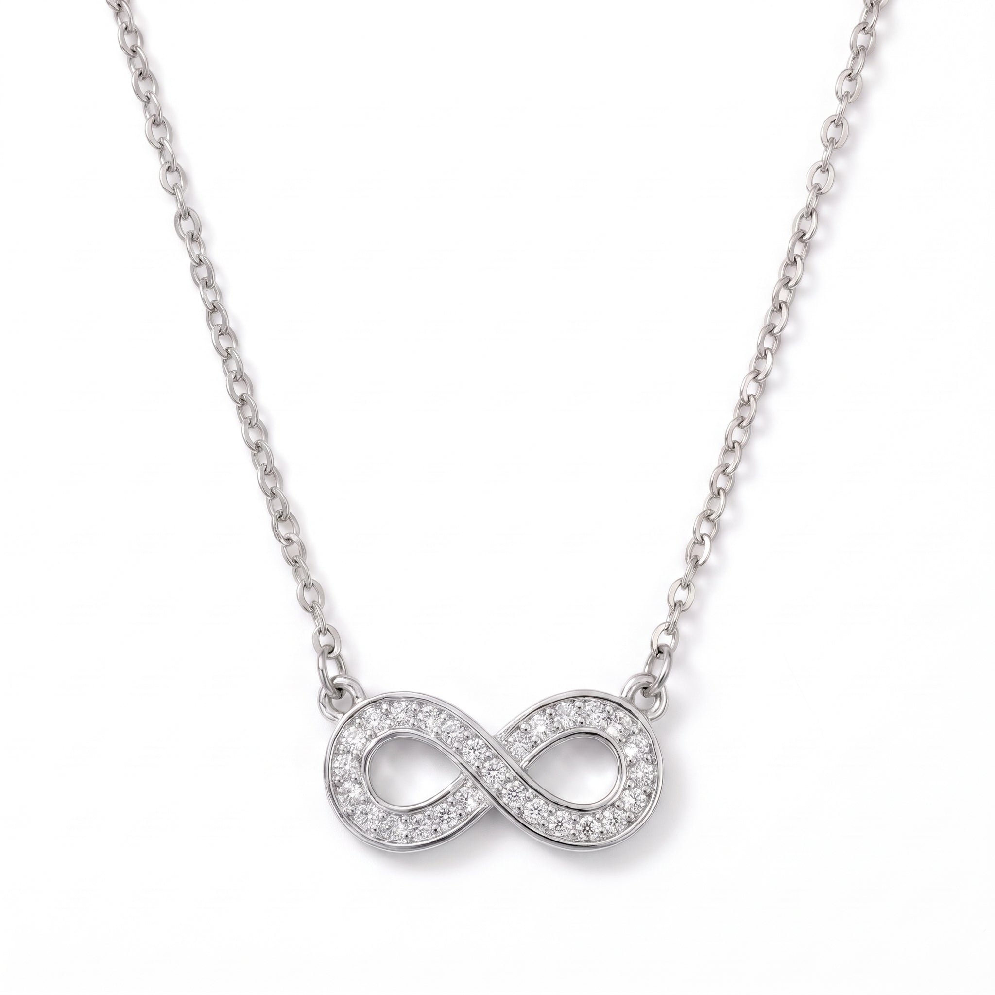 Silver pavé infinity necklace laid out on a white background