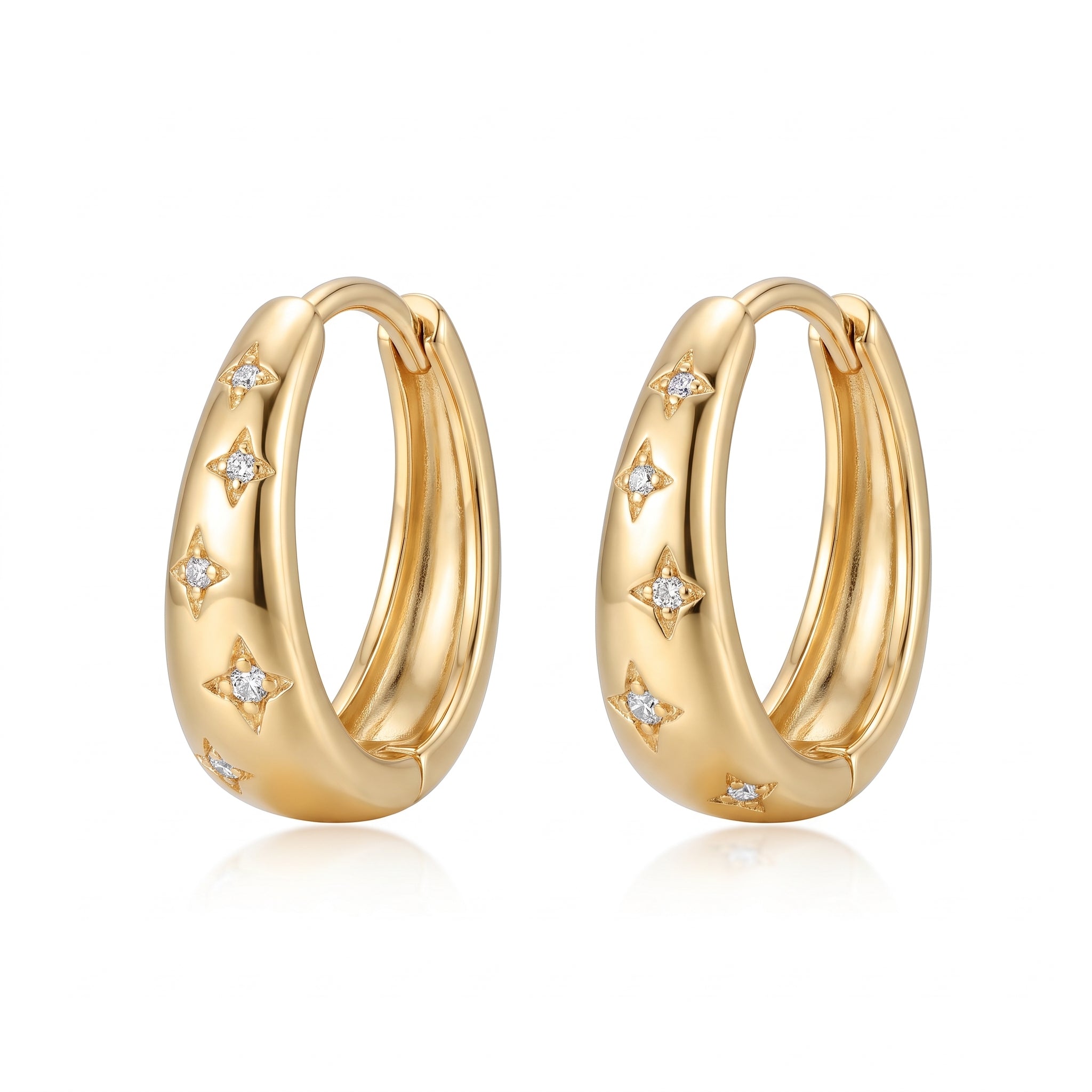 Gold star huggie hoop earrings side by side on white