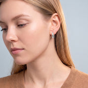 Silver star huggie earring in a downcast portrait