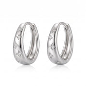 Silver star huggie hoop earrings side by side on white