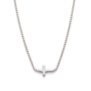 Silver sideways cross necklace laid out on a white background