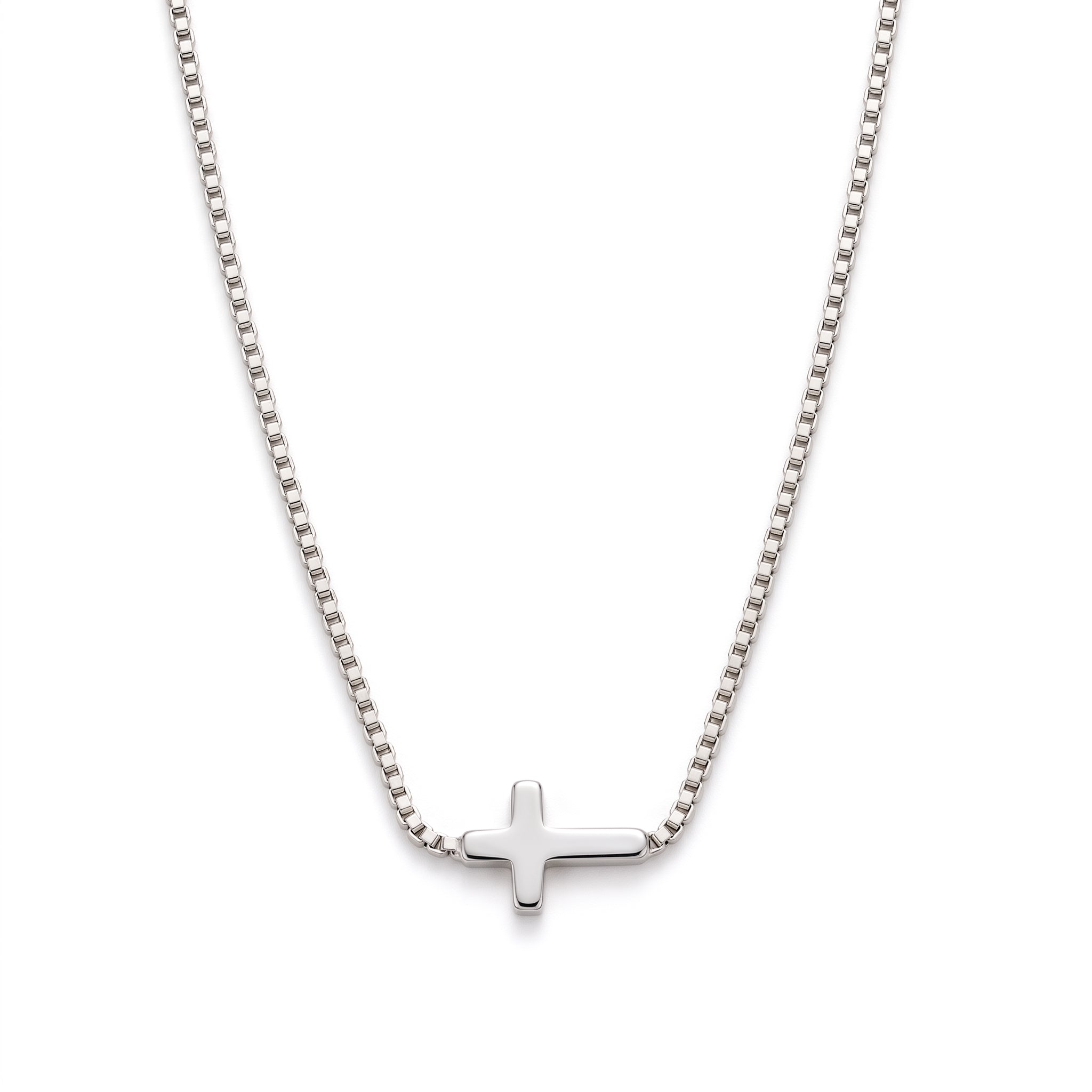 Silver sideways cross necklace laid out on a white background