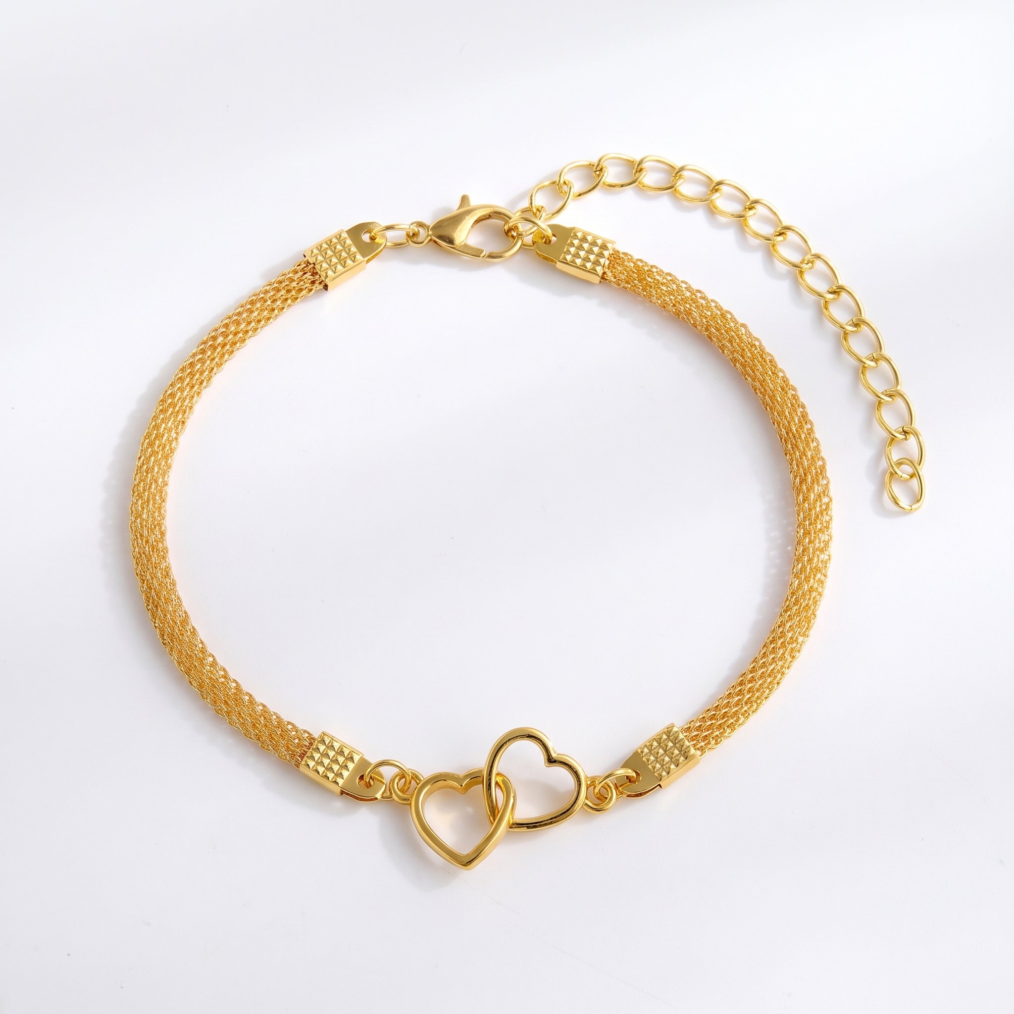 Gold double heart mesh anklet laid flat with extender on white
