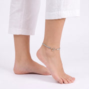 Silver double heart anklet on a foot raised on tiptoe