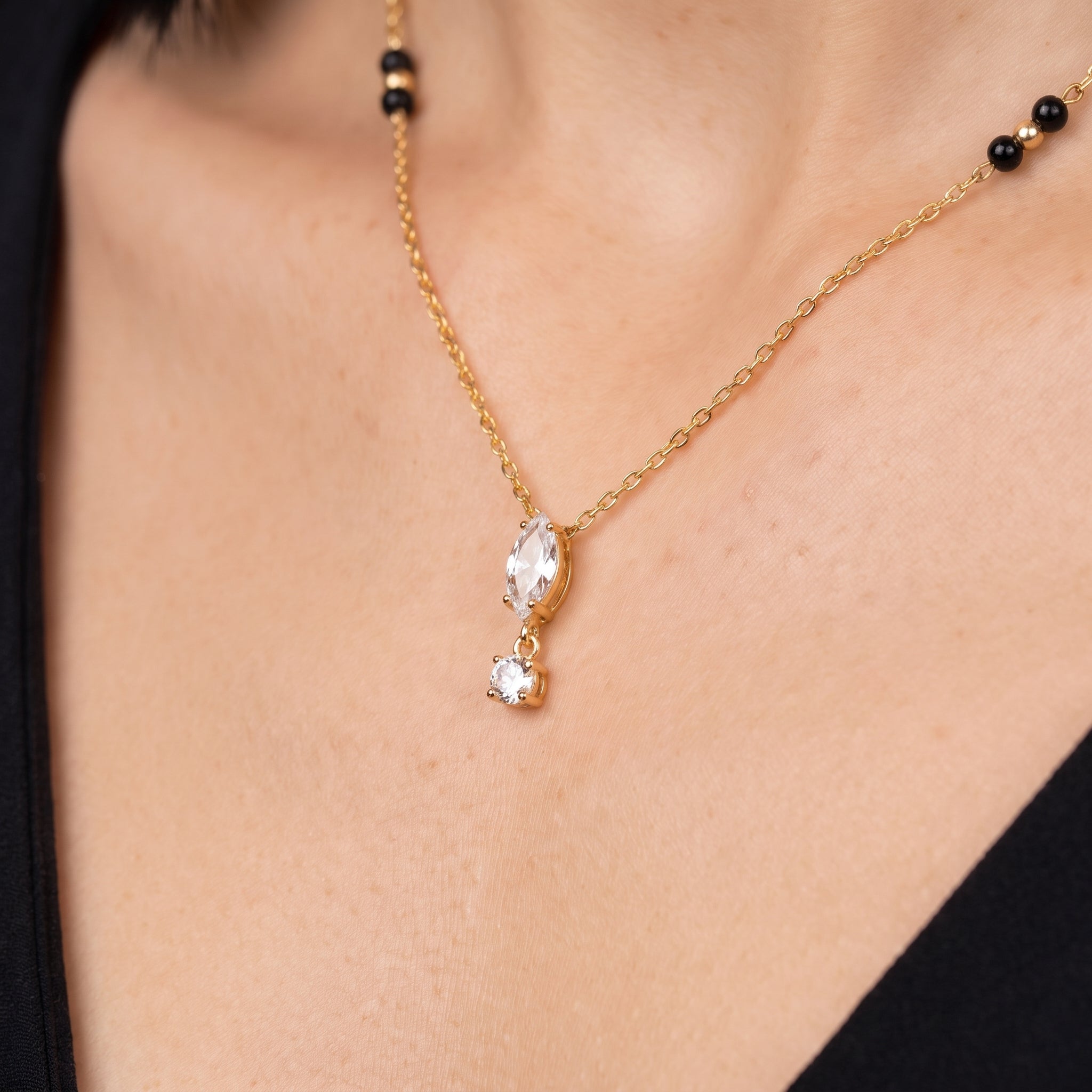 Gold crystal drop necklace, close-up of the marquise drop on skin