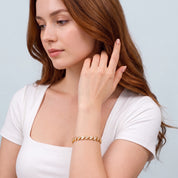 Woman sweeping auburn hair wearing Coralie gold heart tennis bracelet