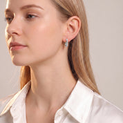 Silver crystal U huggie turned toward the light, white shirt