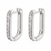 Pair of silver U hoop earrings with cubic zirconia on white