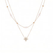 Gold pearl and bead chain with a crystal-set north star on white background