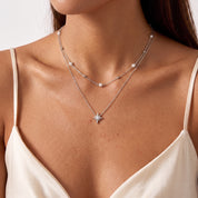Woman wearing Estelle silver pearl star necklace with a satin slip dress