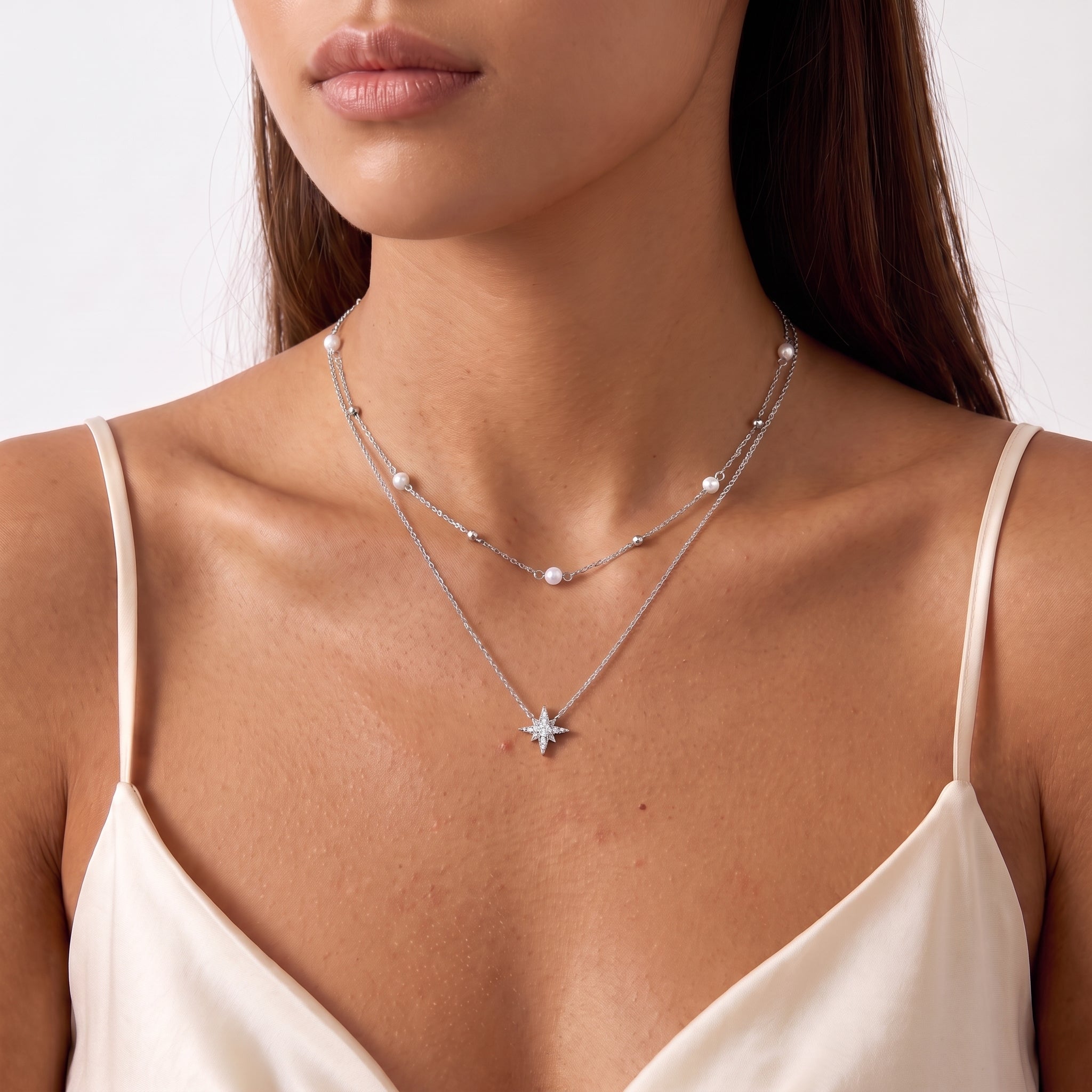 Lower face and neckline showing tiny pearls and a silver star pendant
