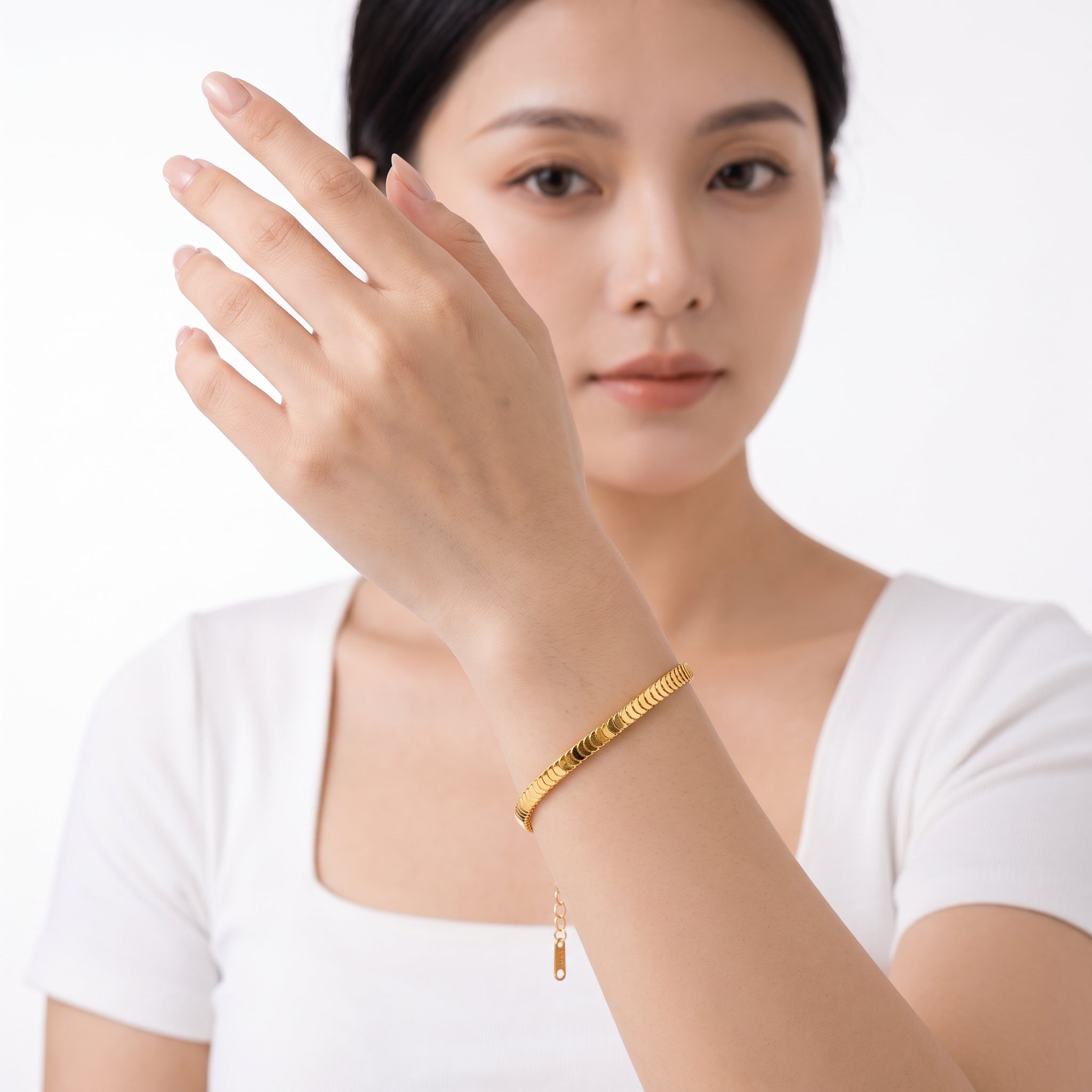 Gold fish scale bracelet with the hand near the face