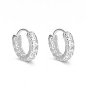 Silver coin huggie earrings side by side on white