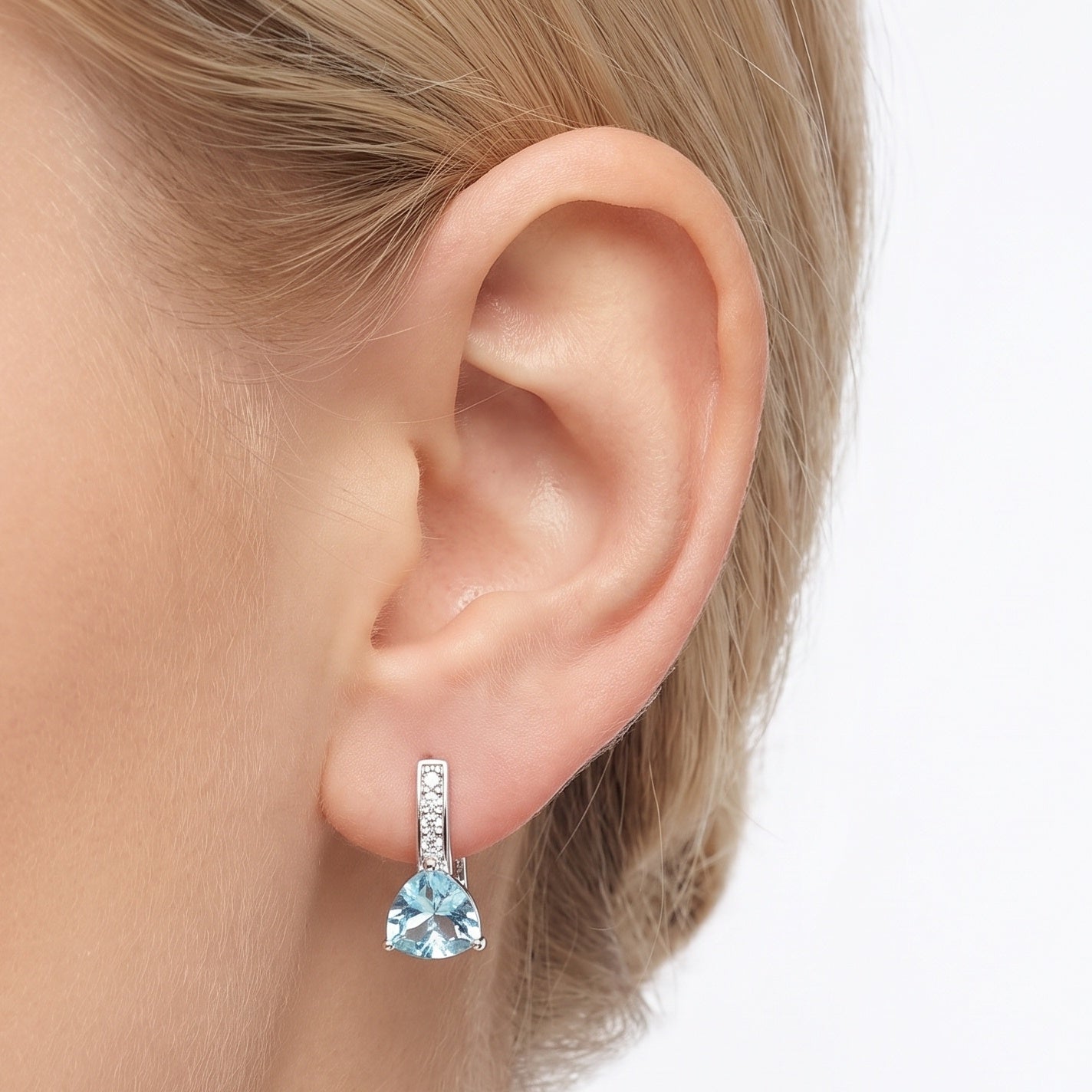 Silver blue crystal drop earring, trillion-cut stone, worn on the ear