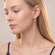 Silver blue crystal drop earring in a downcast side portrait