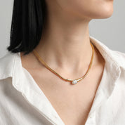 Ilsa gold snake necklace, at the base of the neck with an ivory linen shirt