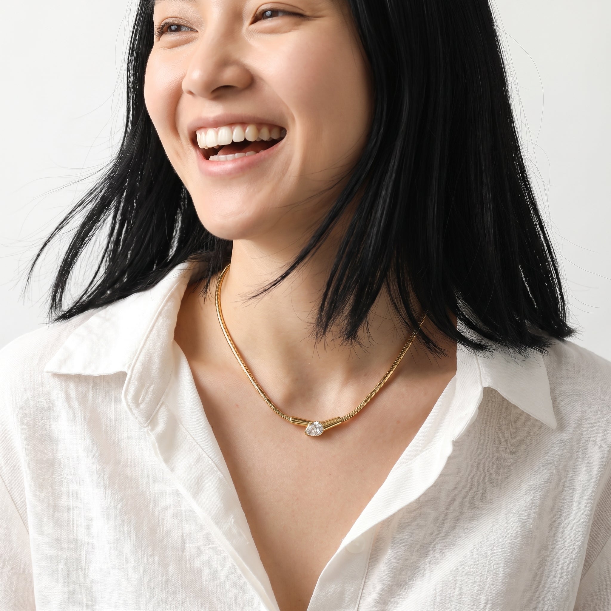 Ilsa gold snake necklace, worn with a laugh in an ivory linen shirt