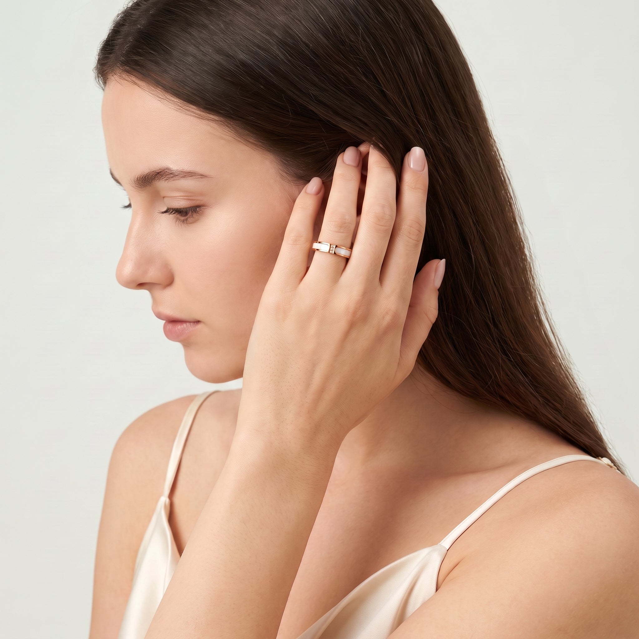 Rose gold shell ring worn while tucking hair behind the ear