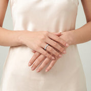 Silver shell ring worn with hands clasped at the waist