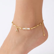 Gold bamboo anklet with crystal leaf charm worn on the ankle