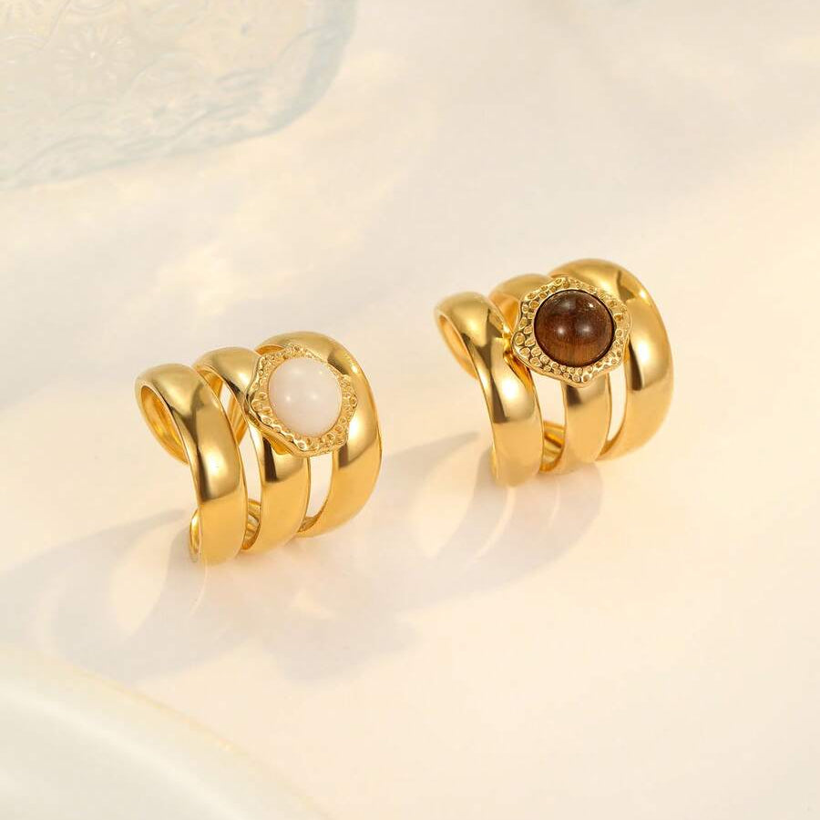 Pair of gold earrings with gemstones on a light background