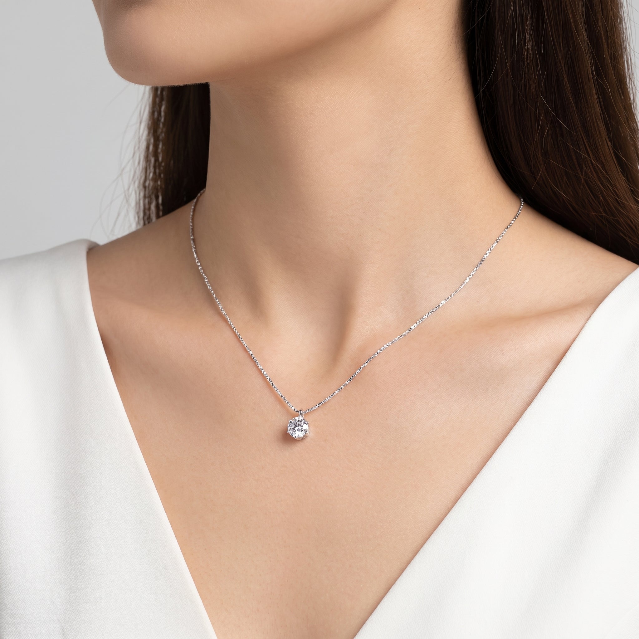 Silver solitaire crystal necklace on a sparkle chain, worn at the neck