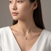 Silver solitaire necklace worn with a glance over the shoulder