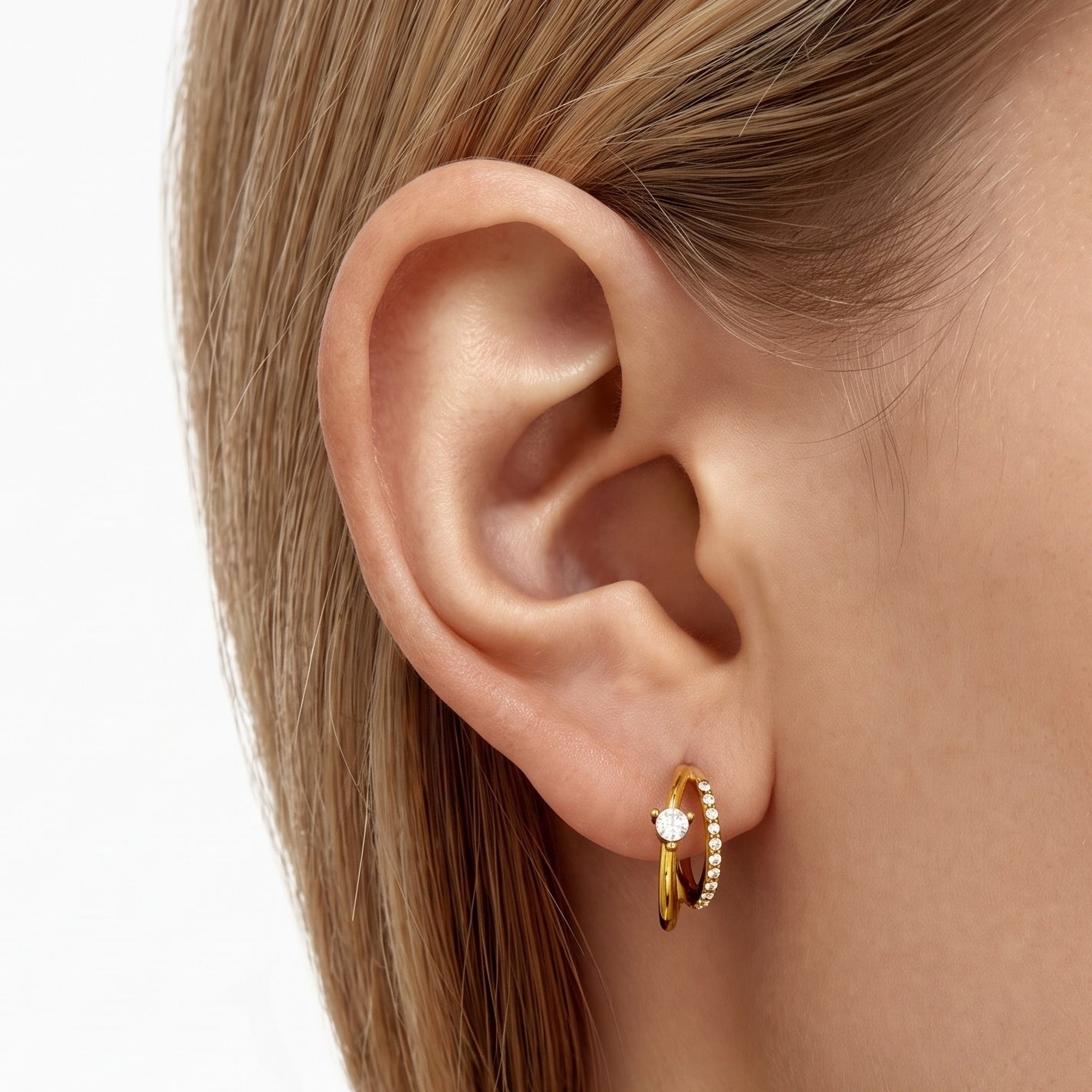 Gold double hoop earrings with a crystal row worn on the earlobe