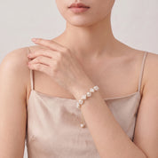 Gold pearl bracelet with the hand at the collar
