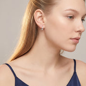 Silver teardrop hoop earring worn with a navy camisole