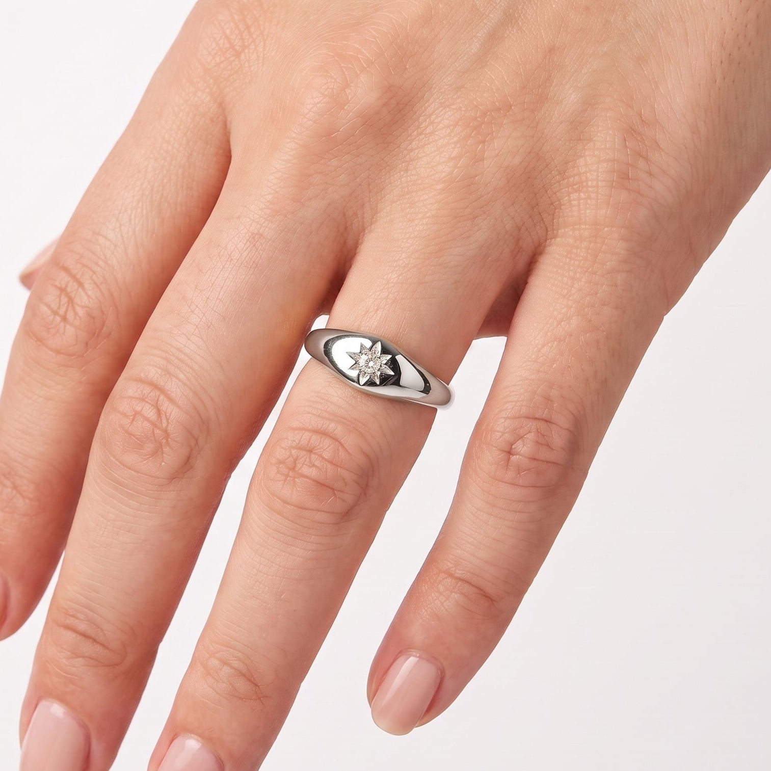 Silver star signet ring with crystal worn on the hand