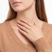 Silver star signet ring worn with the hand at the collarbone
