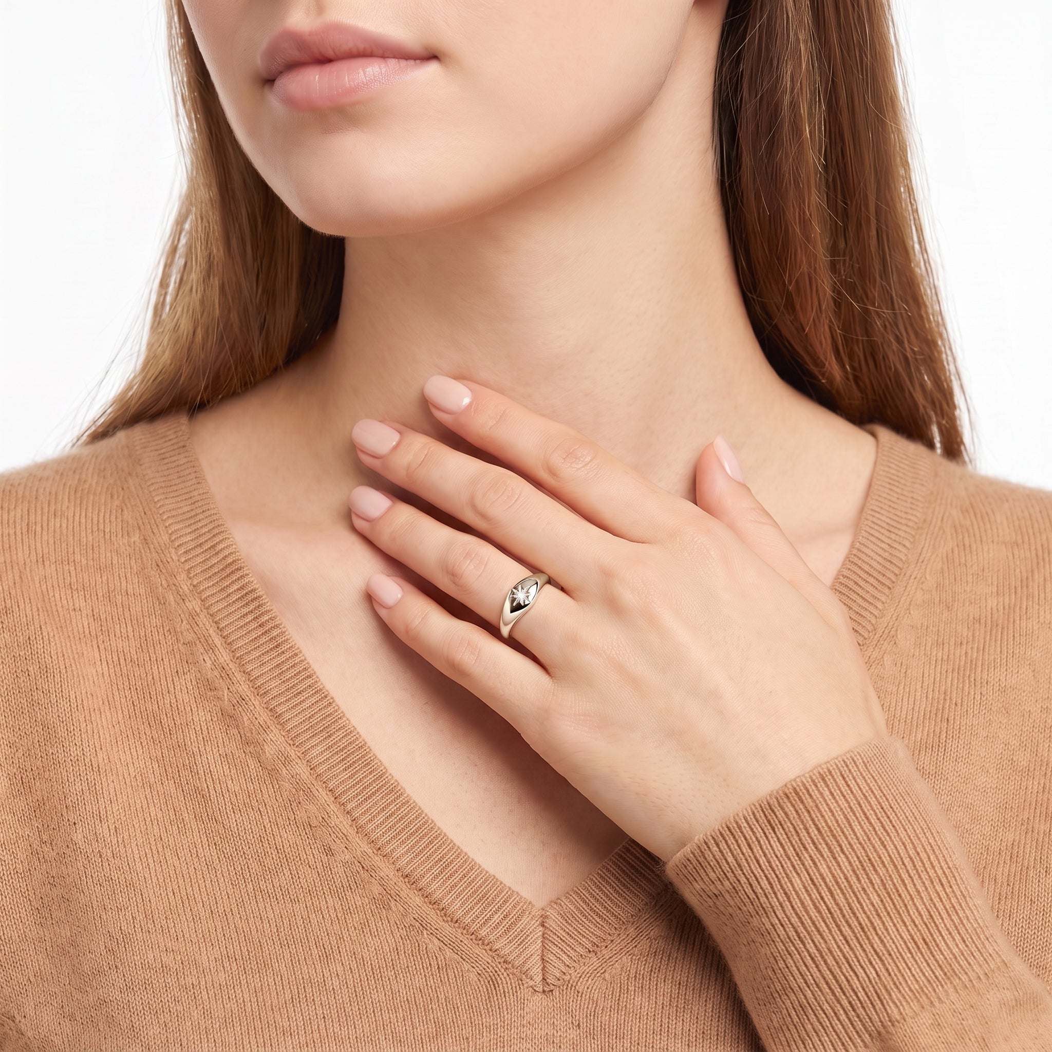 Silver star signet ring worn with the hand at the collarbone