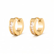 Pair of Maelle gold huggie earrings with square-cut crystals on white background