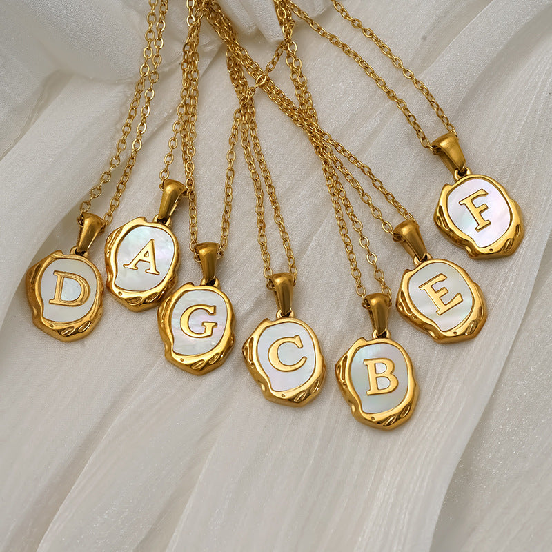 Maelle gold initial necklaces laid out with letters A to G