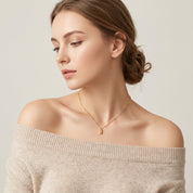 Gold bar necklace worn with hair up, side profile