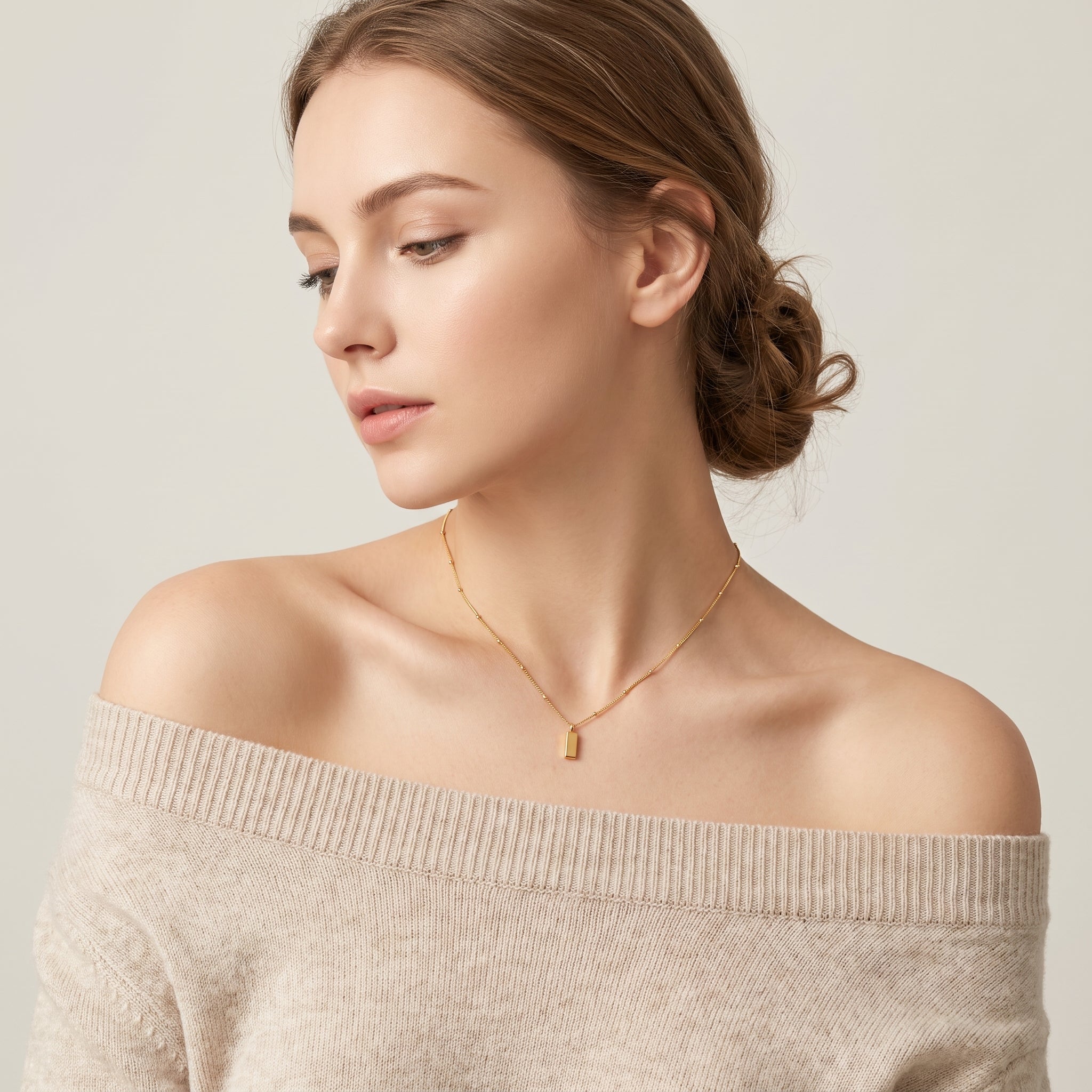 Gold bar necklace worn with hair up, side profile