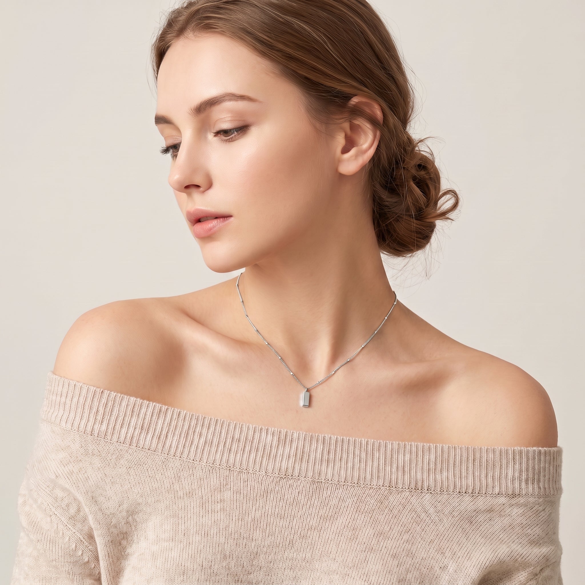 Silver bar necklace worn with hair up, side profile