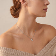 Silver bar necklace worn with an off-shoulder sweater